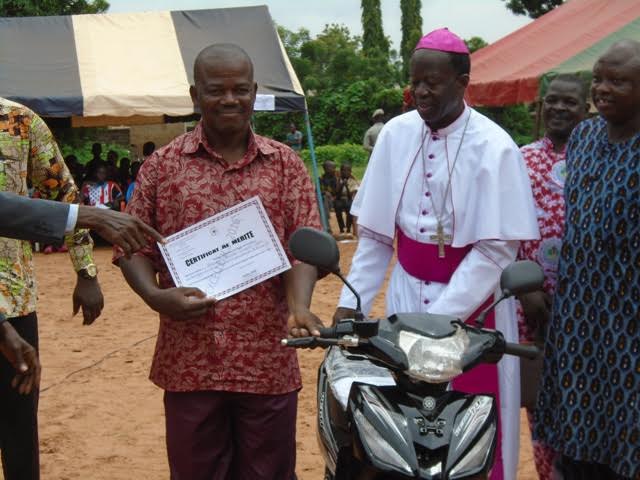 Meilleur enseignant, Sanou Vincent Paul recevant son prix des mains de l’Evêque.