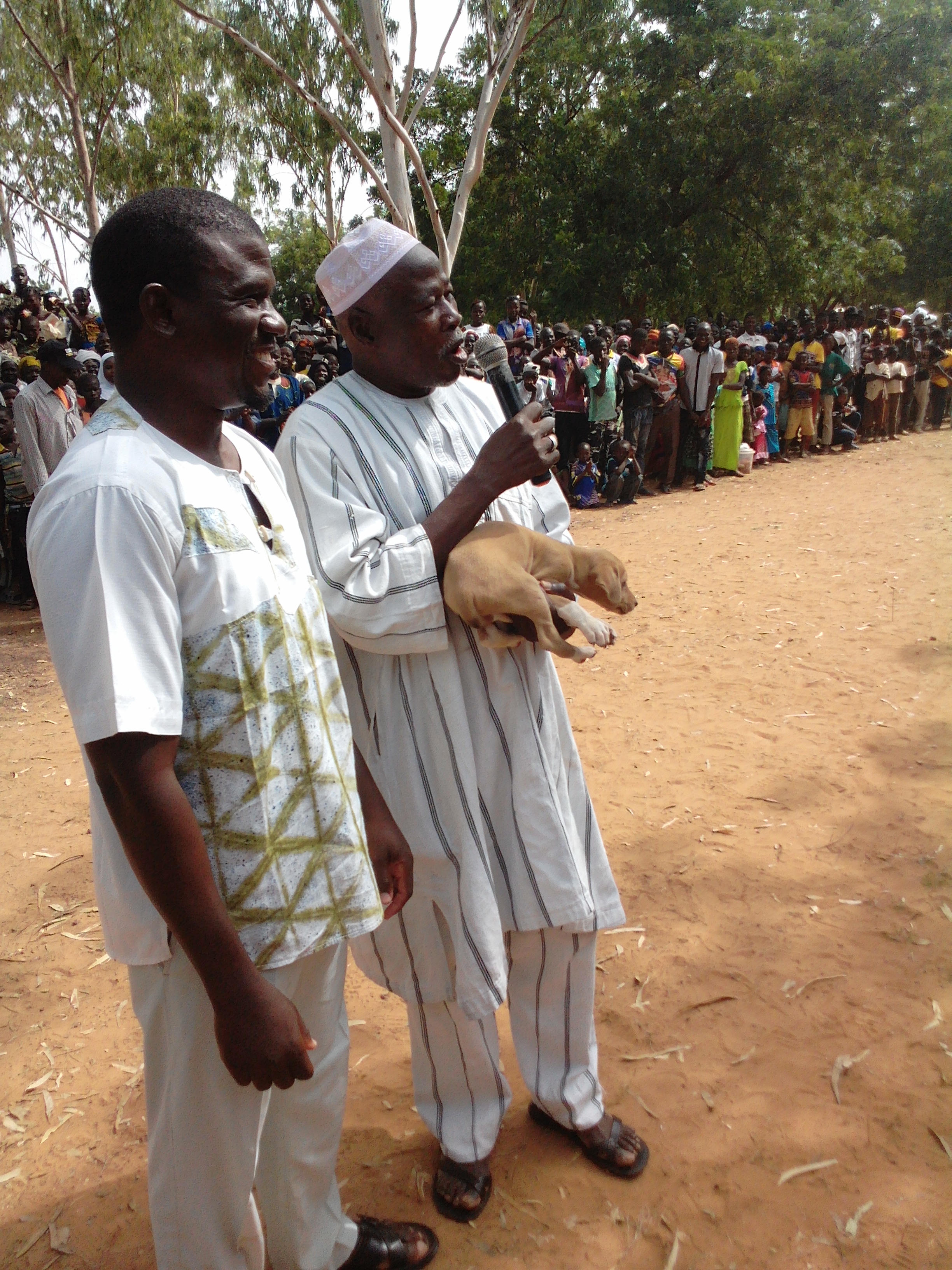 Mr Sow recevant son chiot des mains du parrain Amadé PECE.