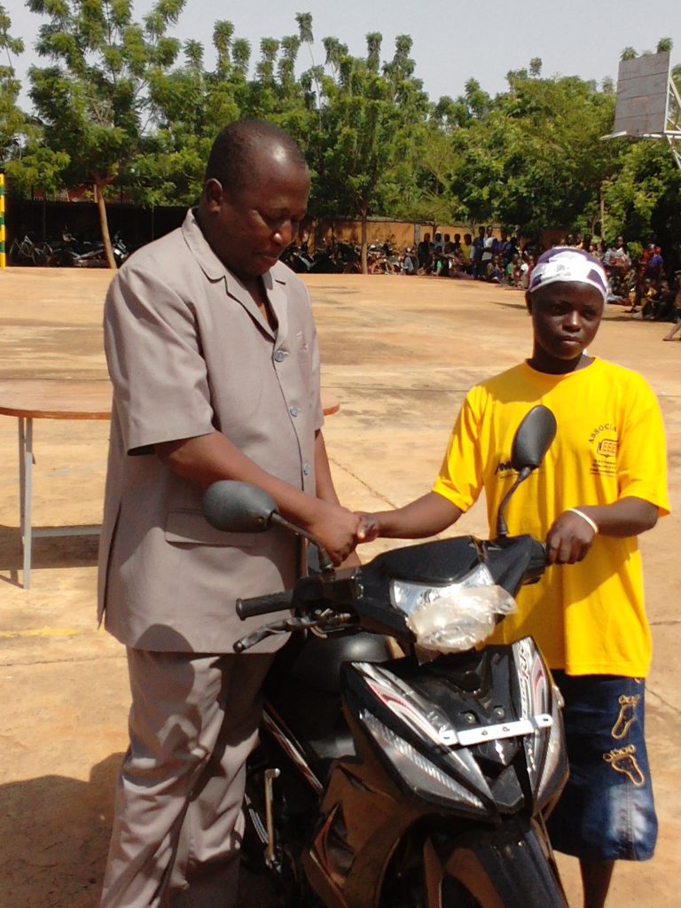 Le coordinateur de NEEED remettant à une lauréate (inscrite en médecine) une moto.